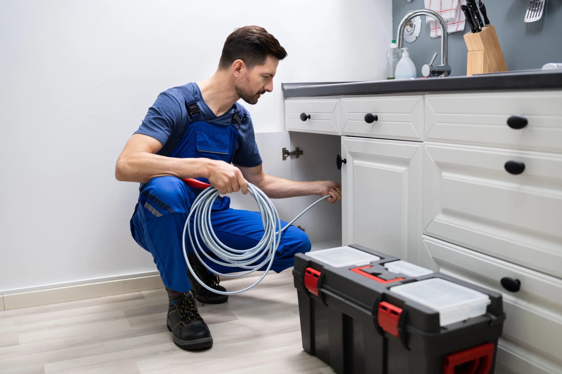 Professional plumber inspecting pipes in a residential utility area
