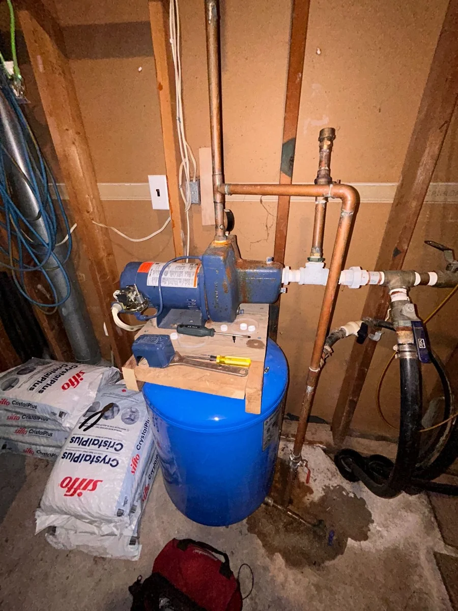 Plumber inspecting well pump controls and water pressure system